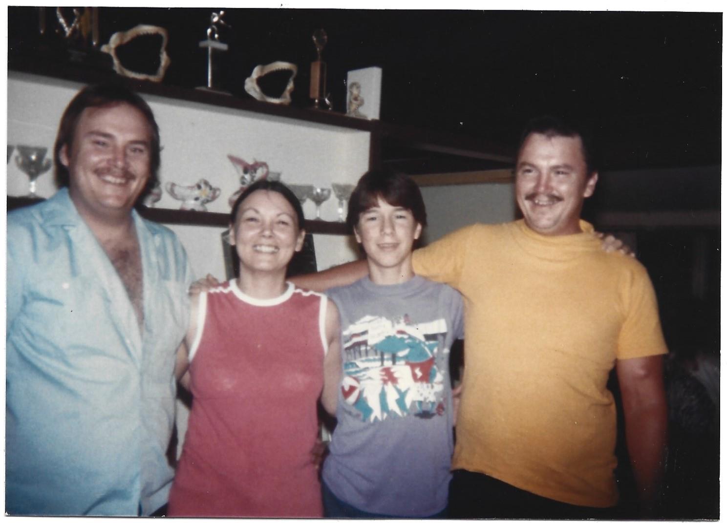 Friends embrace and smile warmly in a relaxed indoor environment, sharing happy moments together.