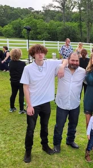 People gather outdoors, celebrating joyfully in the warm sunlight and camaraderie.