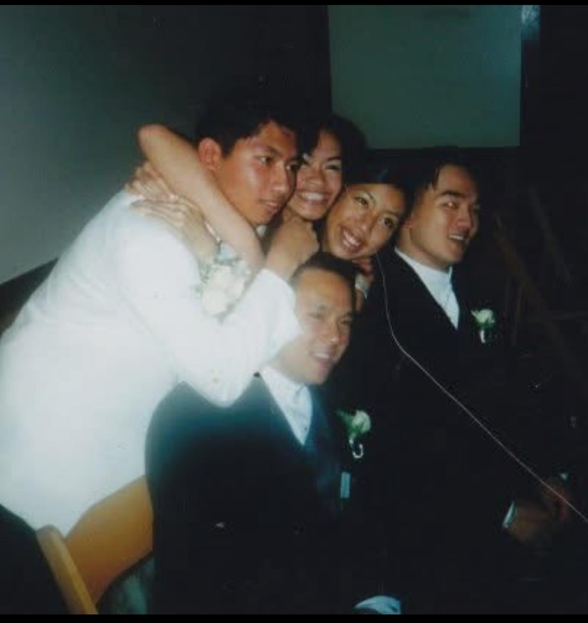 Friends enjoy a fun moment together, embracing and smiling at a lively gathering.