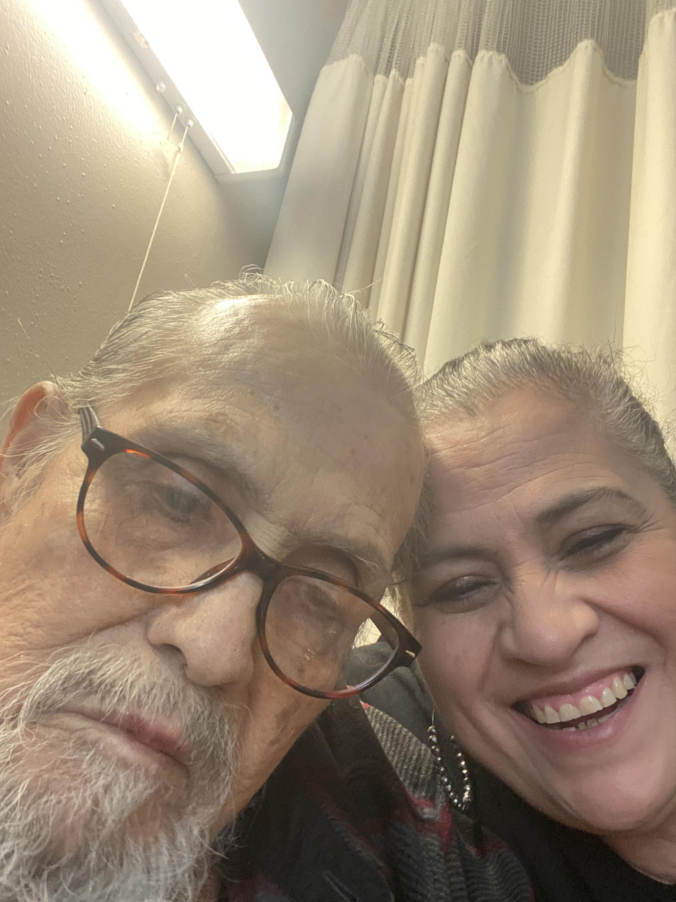 Two individuals share a heartfelt moment, smiling closely together in a comfortable atmosphere.