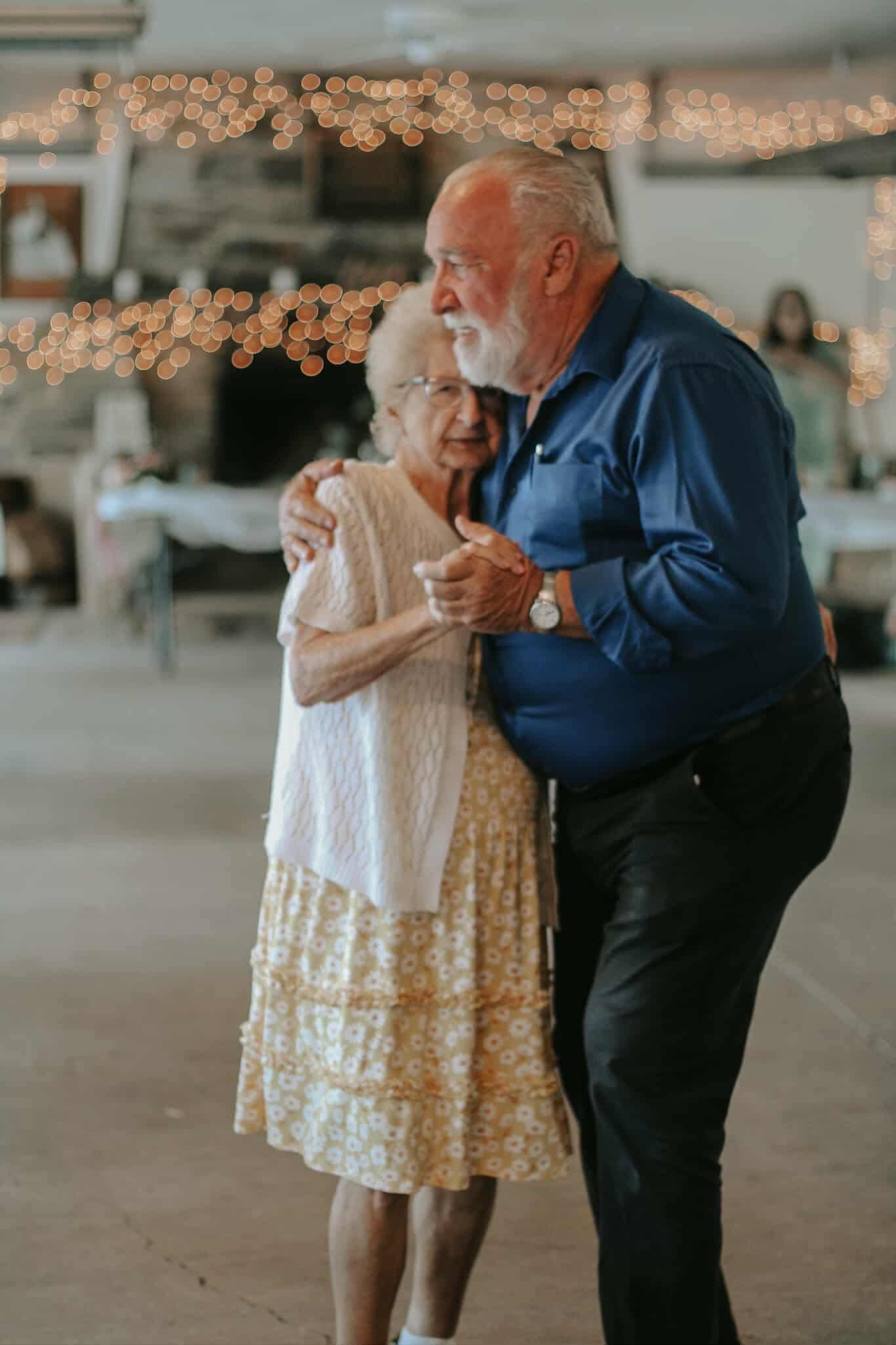 A couple enjoys a heartfelt dance together in a festive atmosphere filled with warmth and joy.
