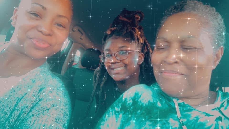 Three friends smile and laugh inside a car, relishing their time together while making memories.