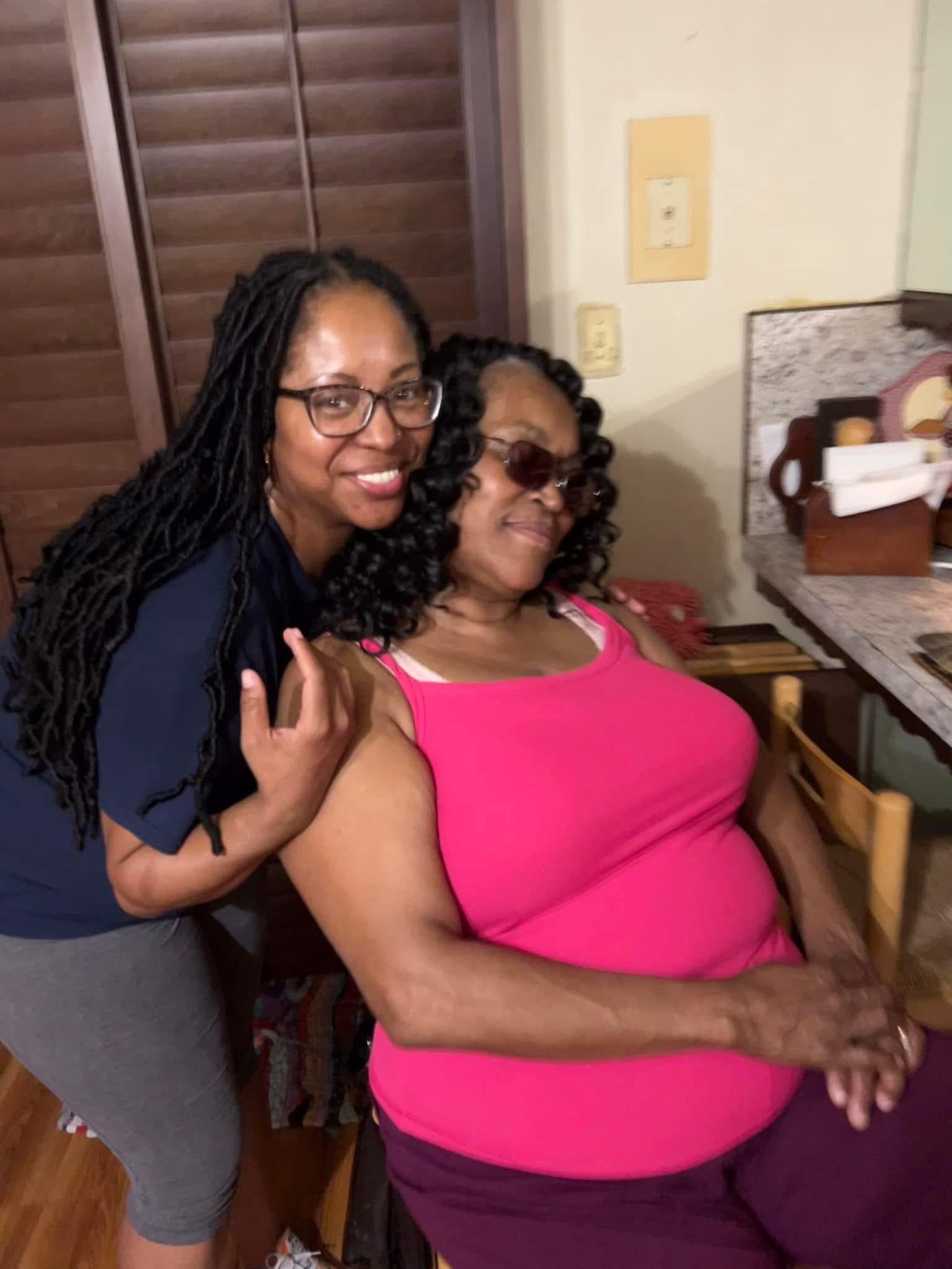 A joyful moment shared between a daughter and her mother in a warm kitchen setting.