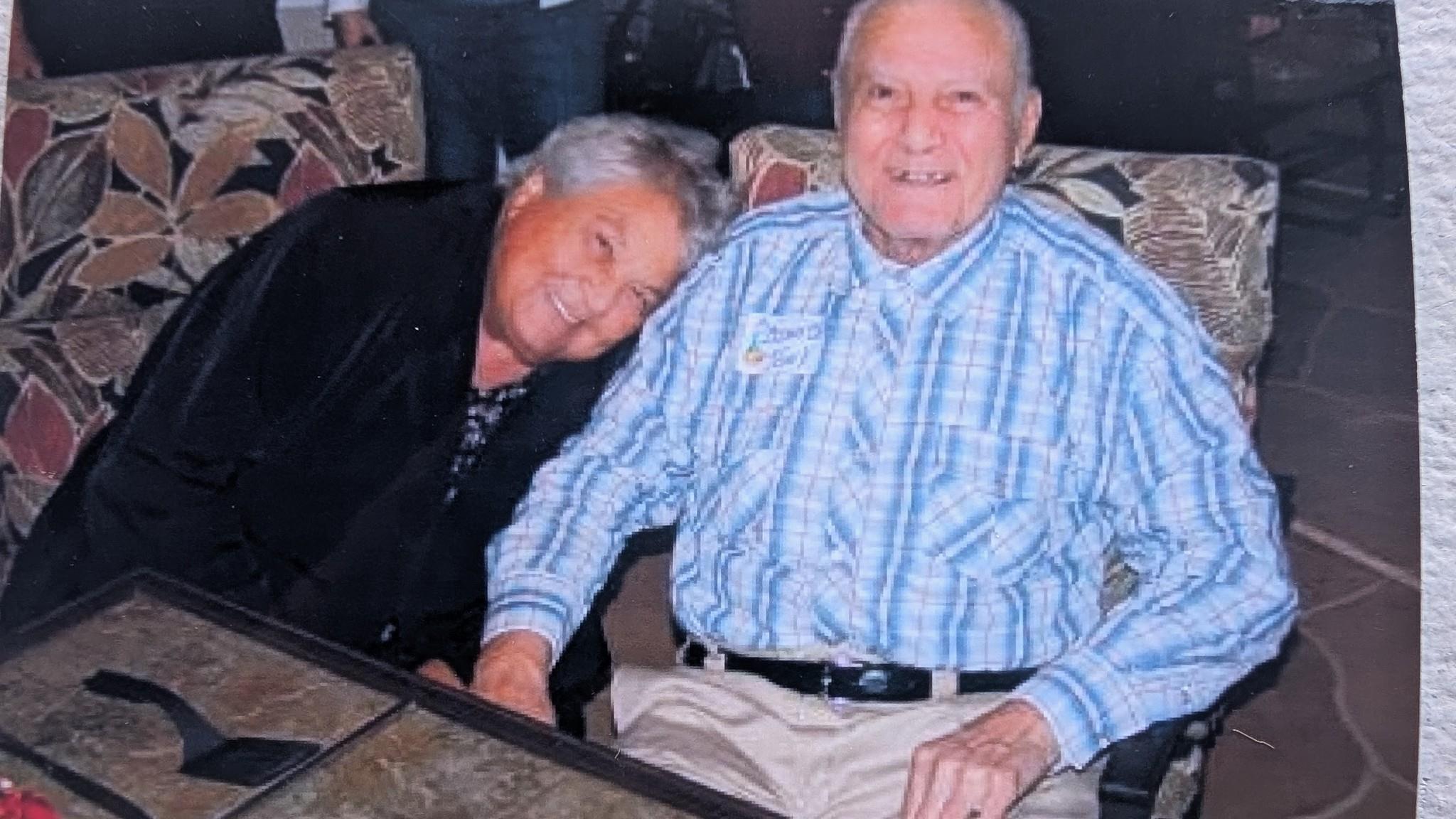 Two elderly individuals share a warm and joyful moment together in a comfortable setting.