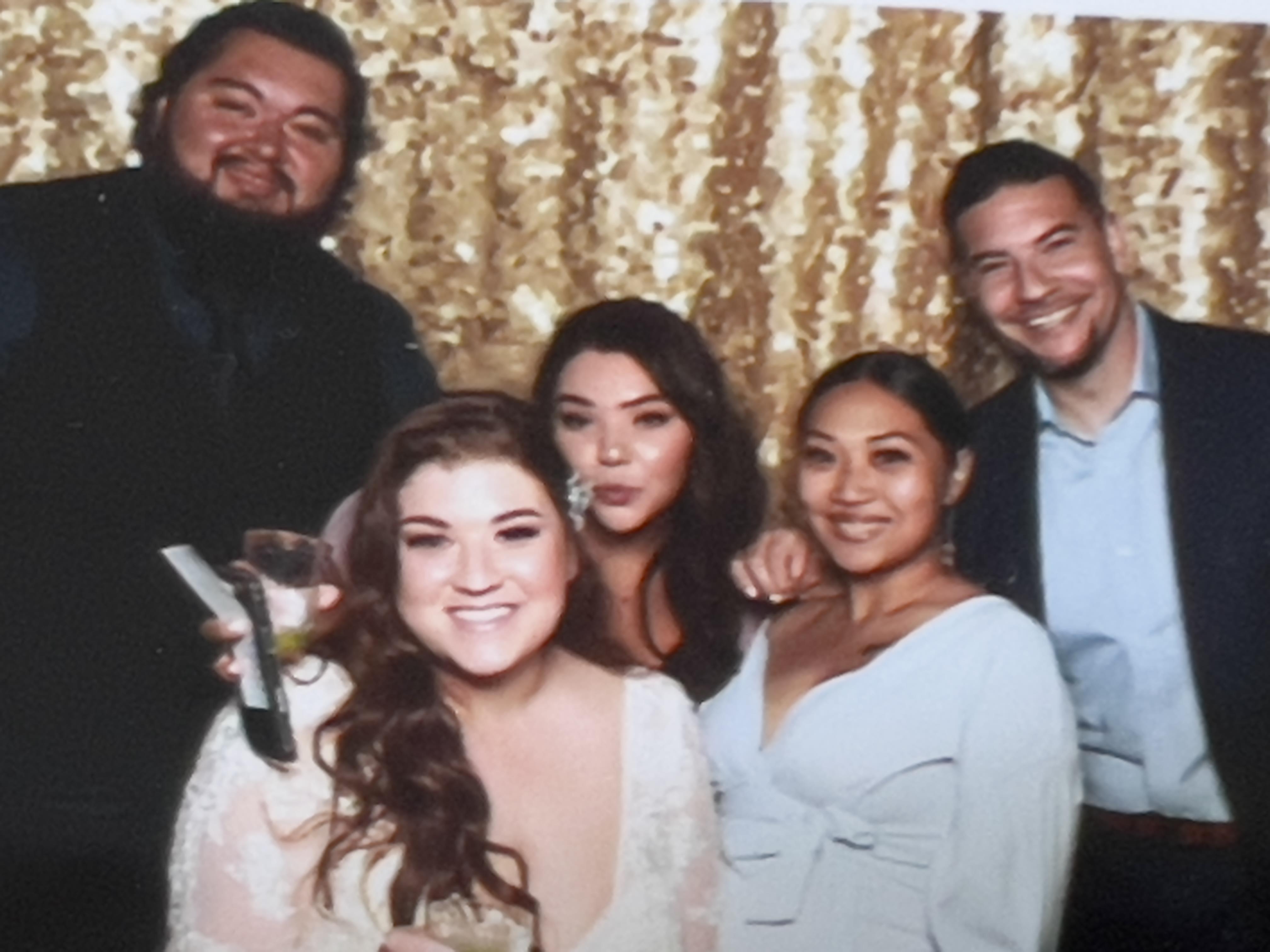 Friends gather together, smiling and posing with drinks at a festive celebration.