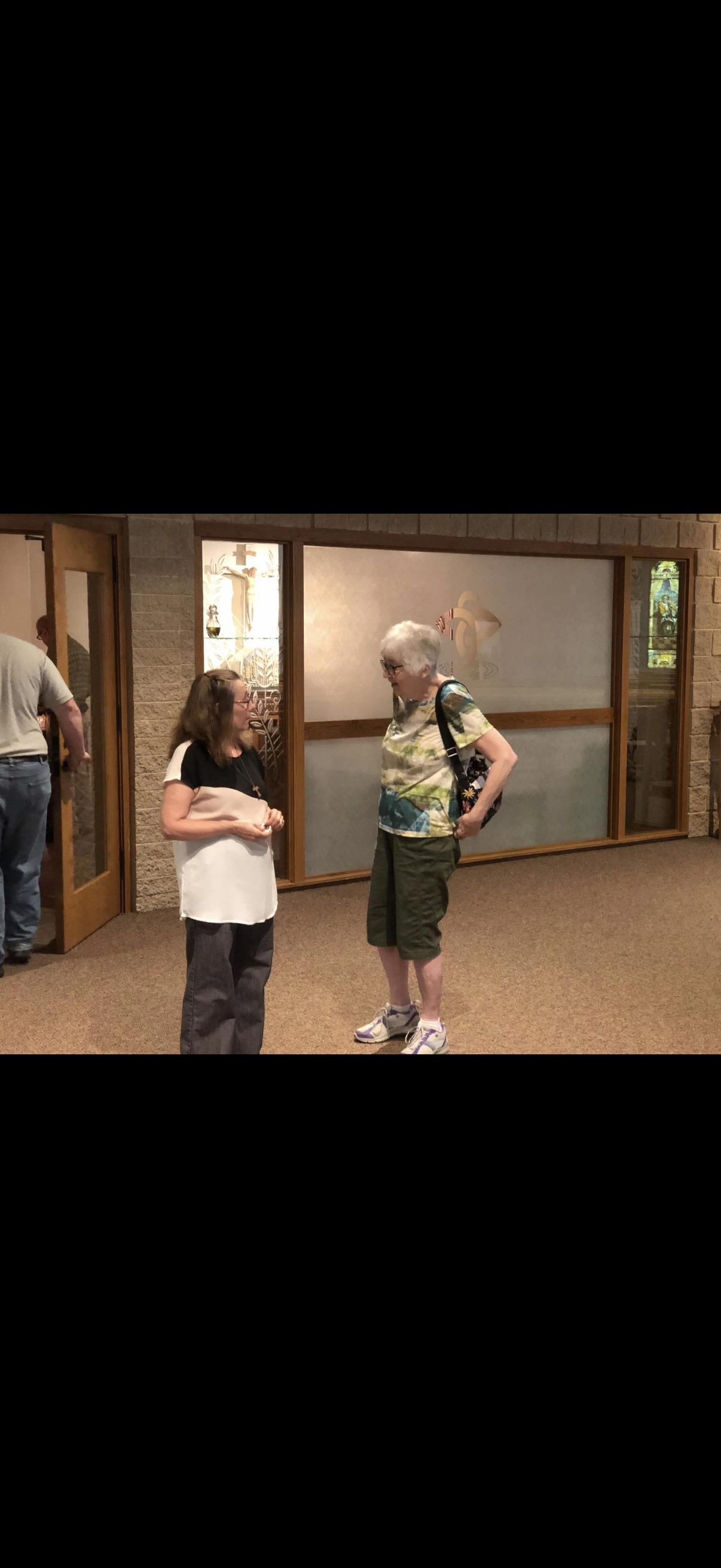 A woman and a woman standing in a hallway