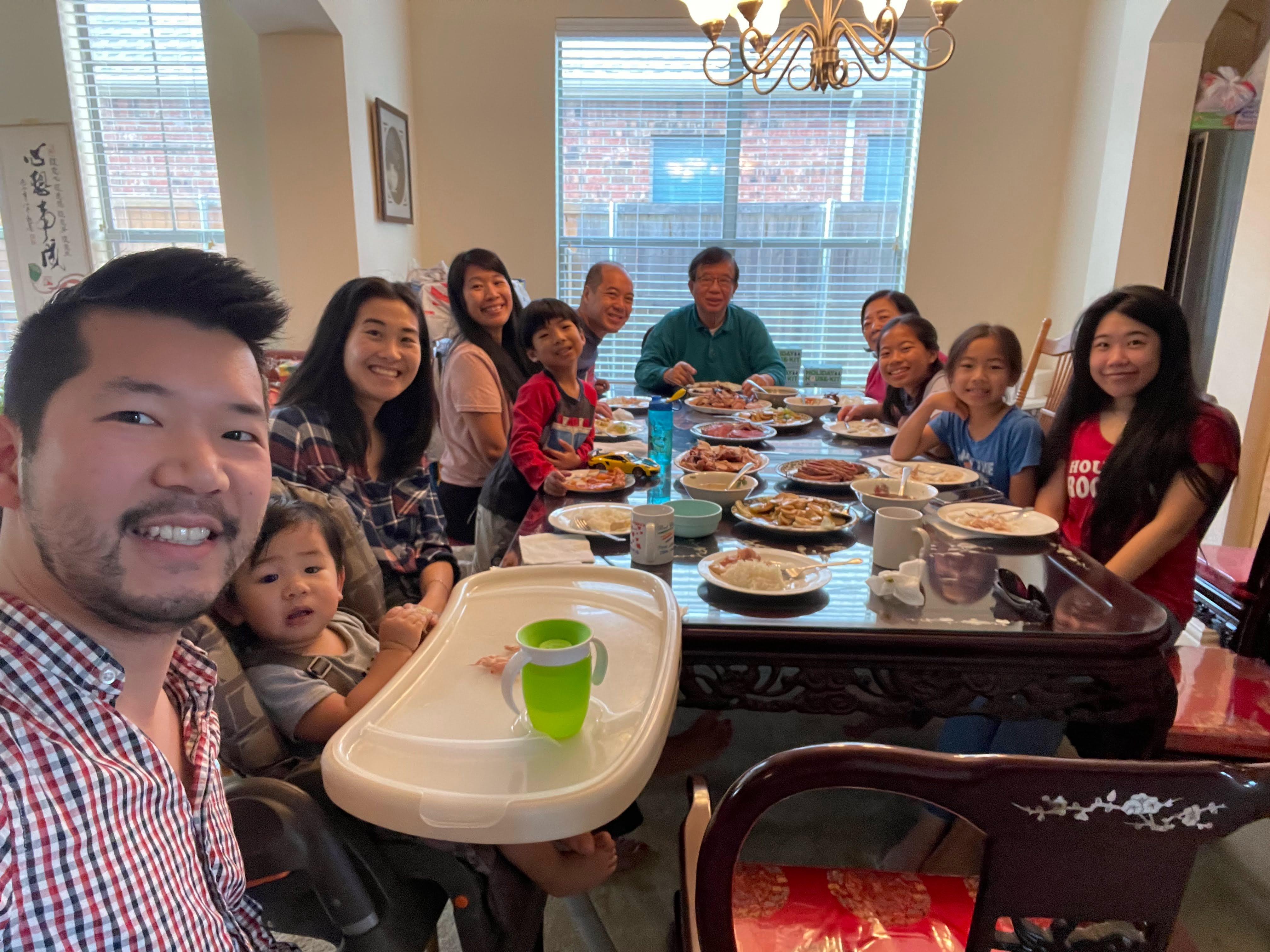 A diverse group of family members enjoys a festive meal together, surrounded by delicious food.
