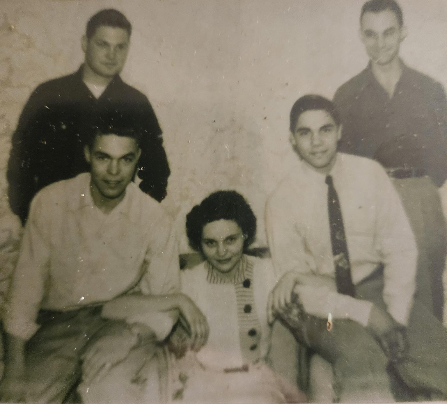 Five friends gather for a joyful moment, showcasing smiles and camaraderie in a vintage environment.
