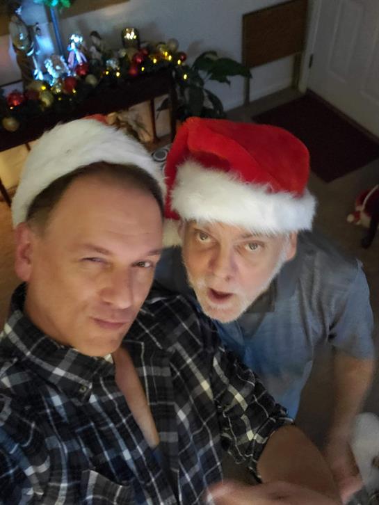 Two men wearing santa hats