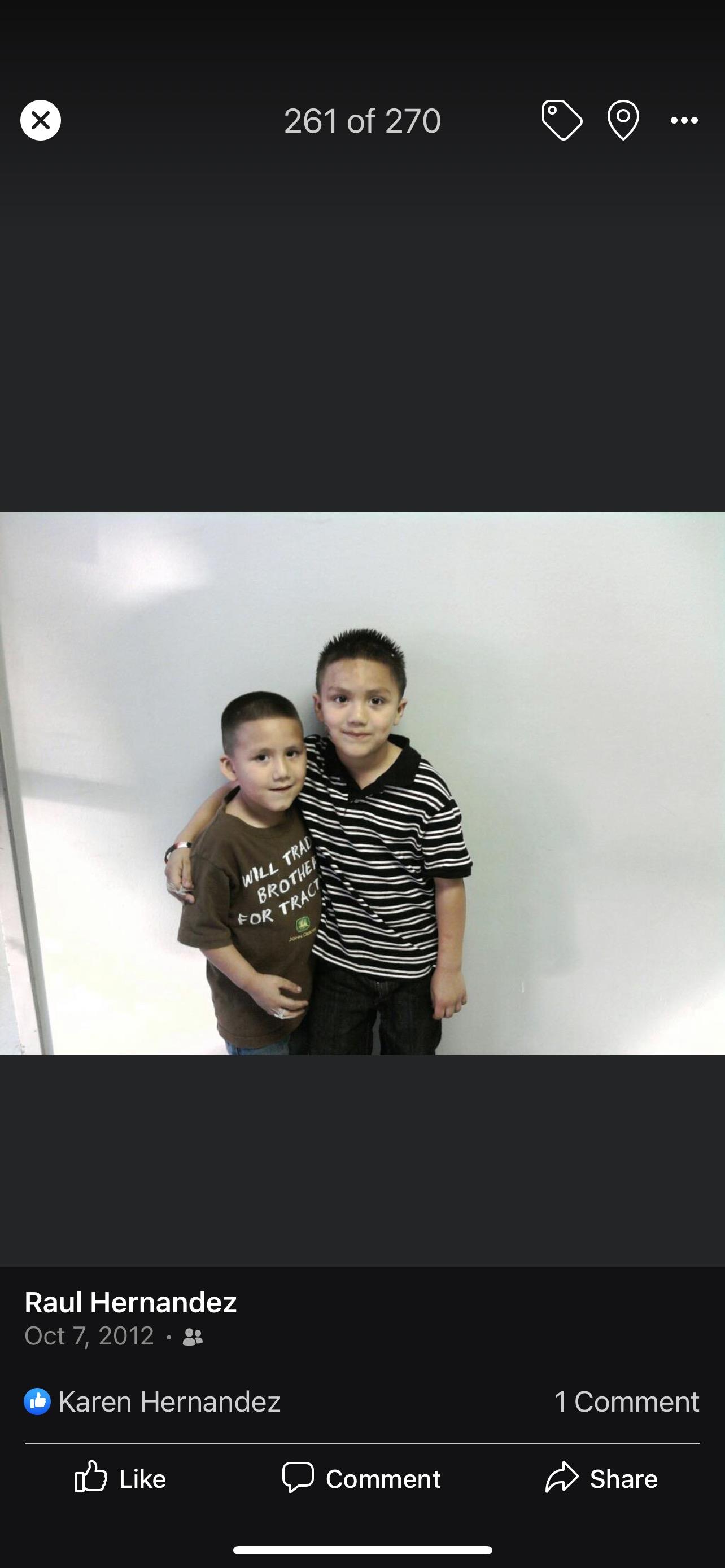 Two boys pose together with big smiles, showcasing their friendship and joy indoors.