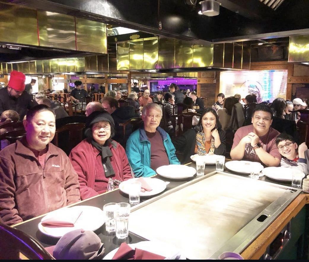 Friends share laughter and good food at a busy restaurant during an evening outing.