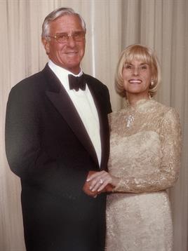 Couple joyfully poses in formal attire, showcasing elegance at a special occasion.