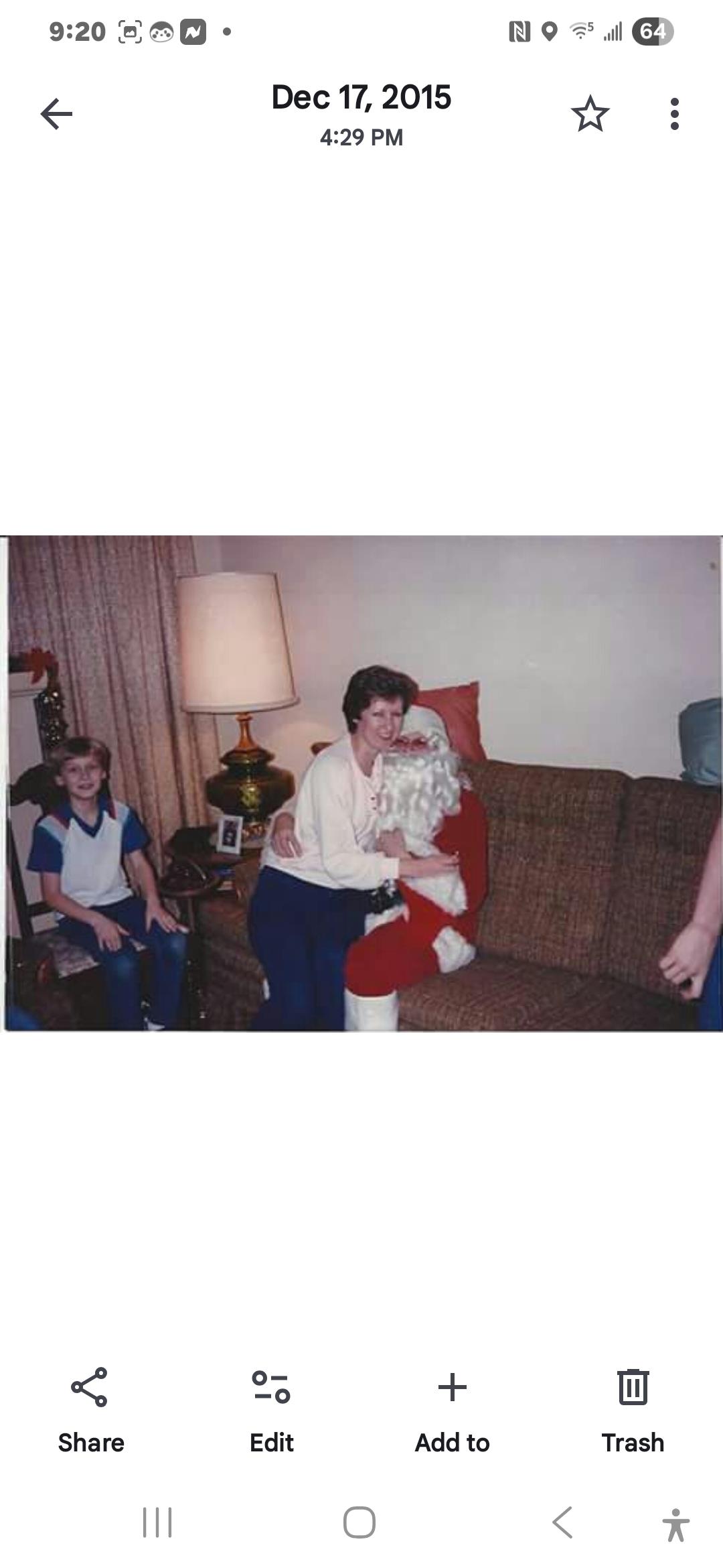 A joyful moment captured with a woman hugging Santa Claus as a boy watches with curiosity.