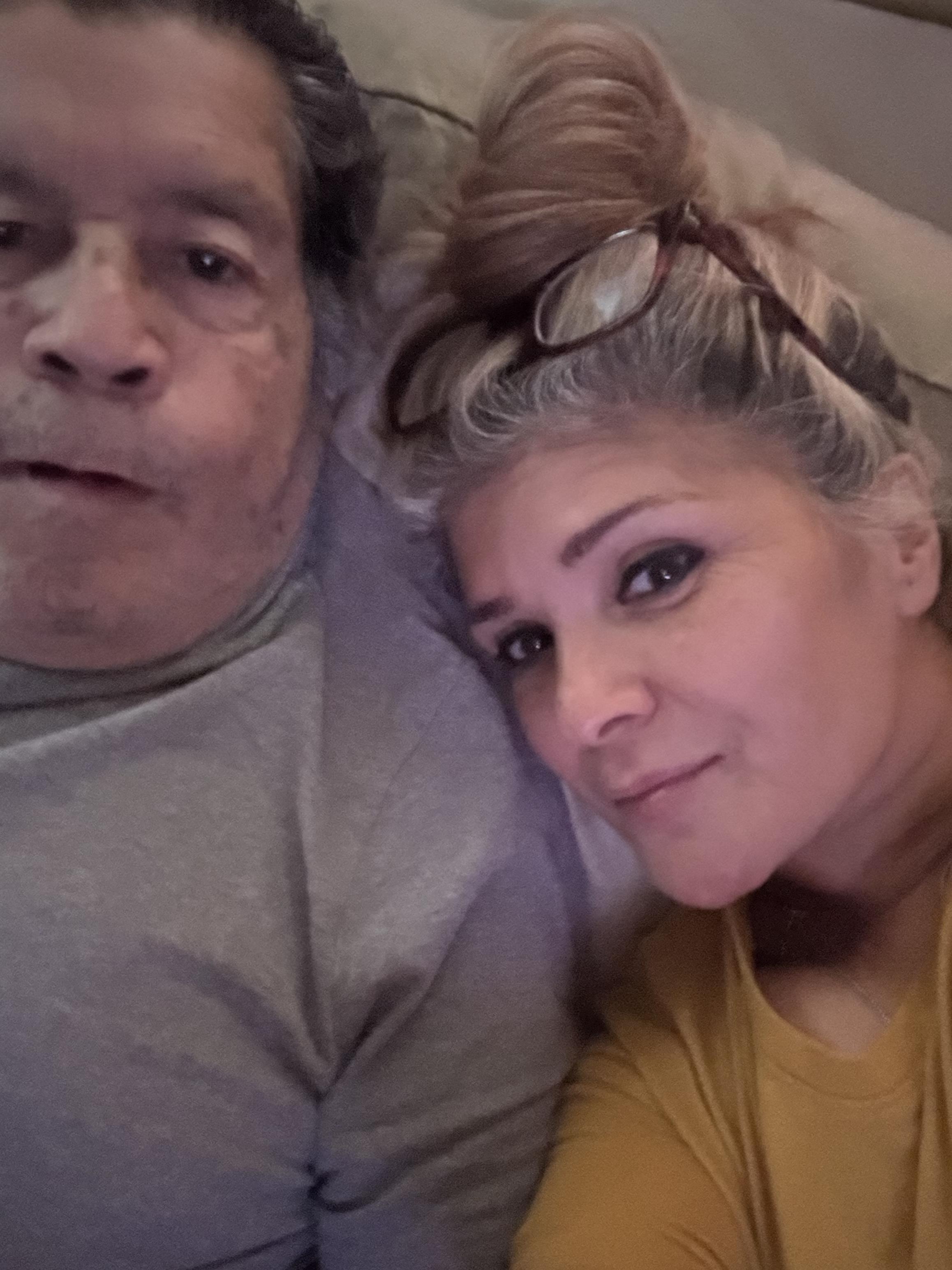 Two family members relax and enjoy each other's company while lying down at home.