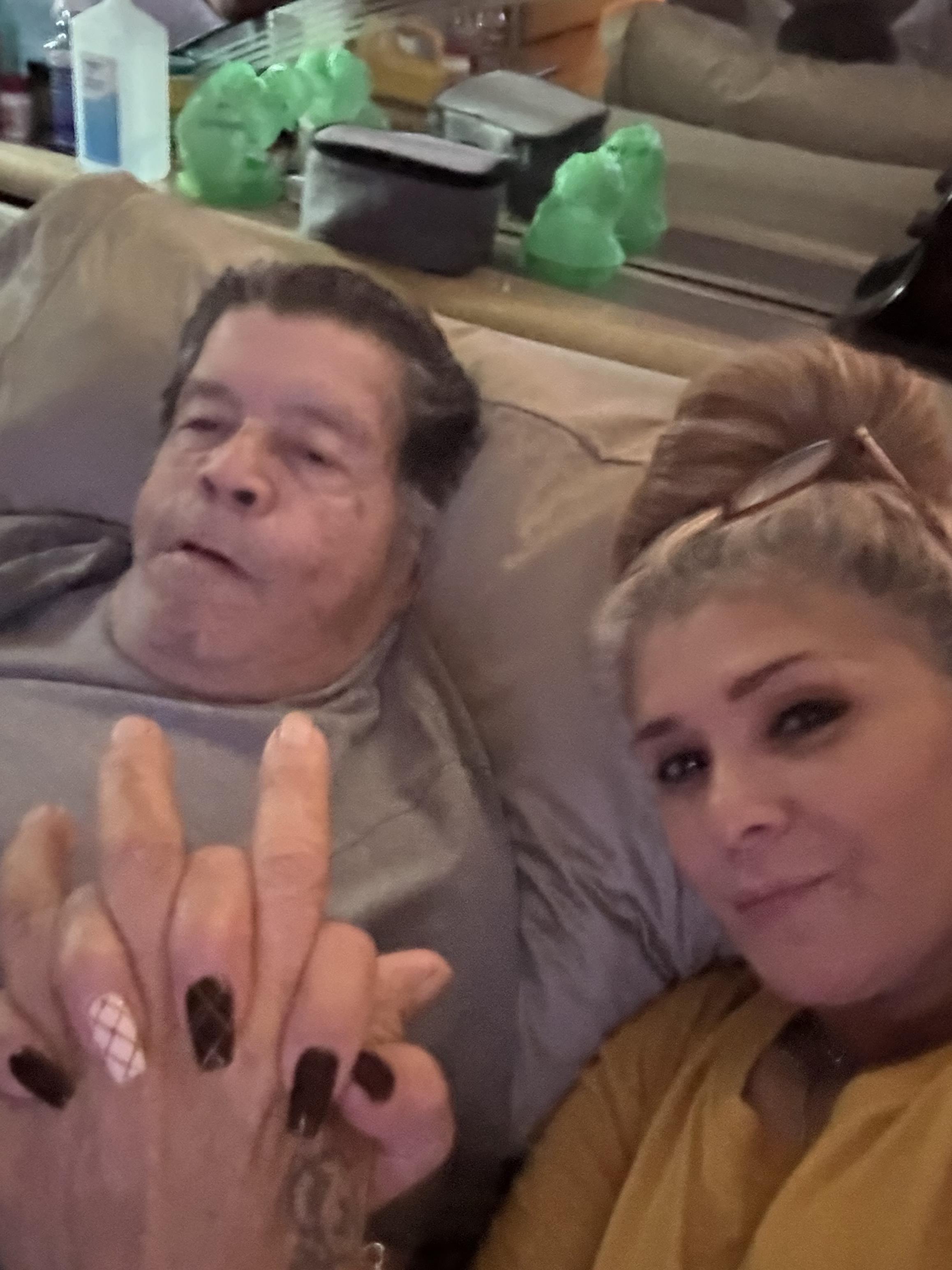 Loving couple shares an affectionate moment while relaxing on the couch, hands intertwined.