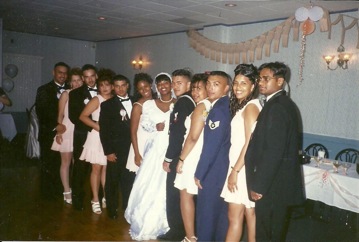 Friends and family in formal attire gather for a festive celebration in a decorated venue.