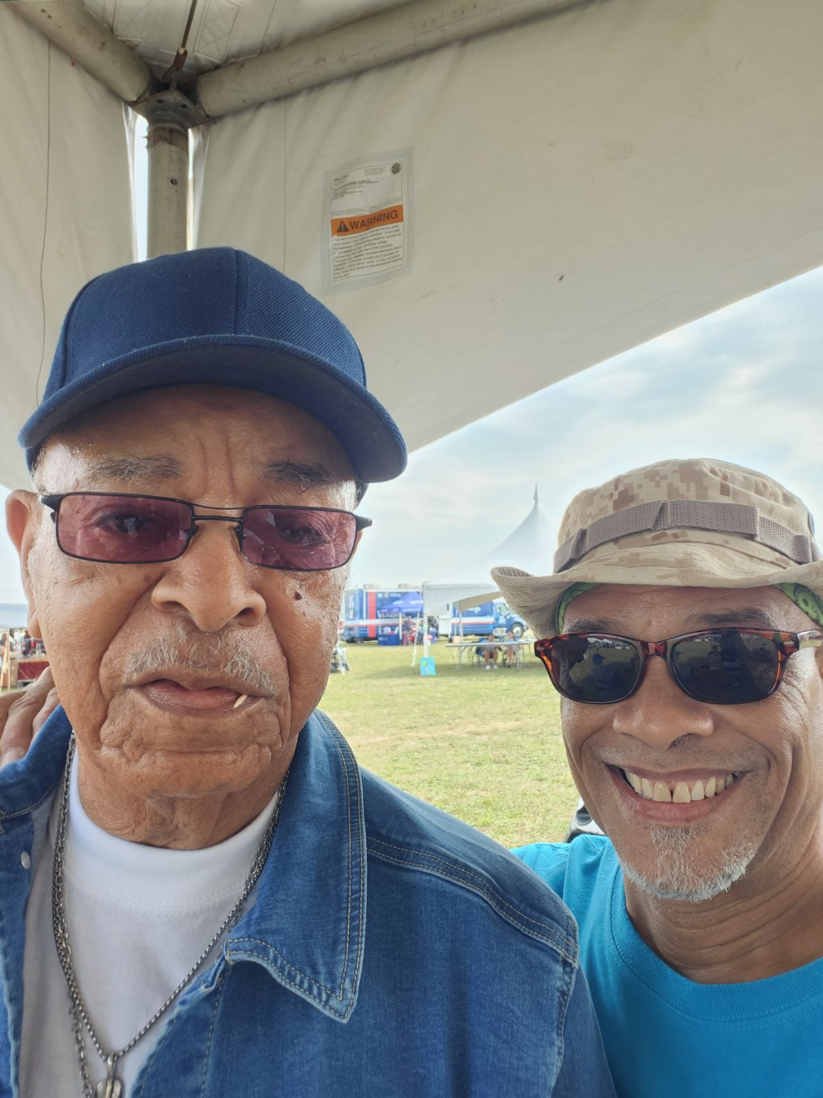 Two men wearing sunglasses and a hat