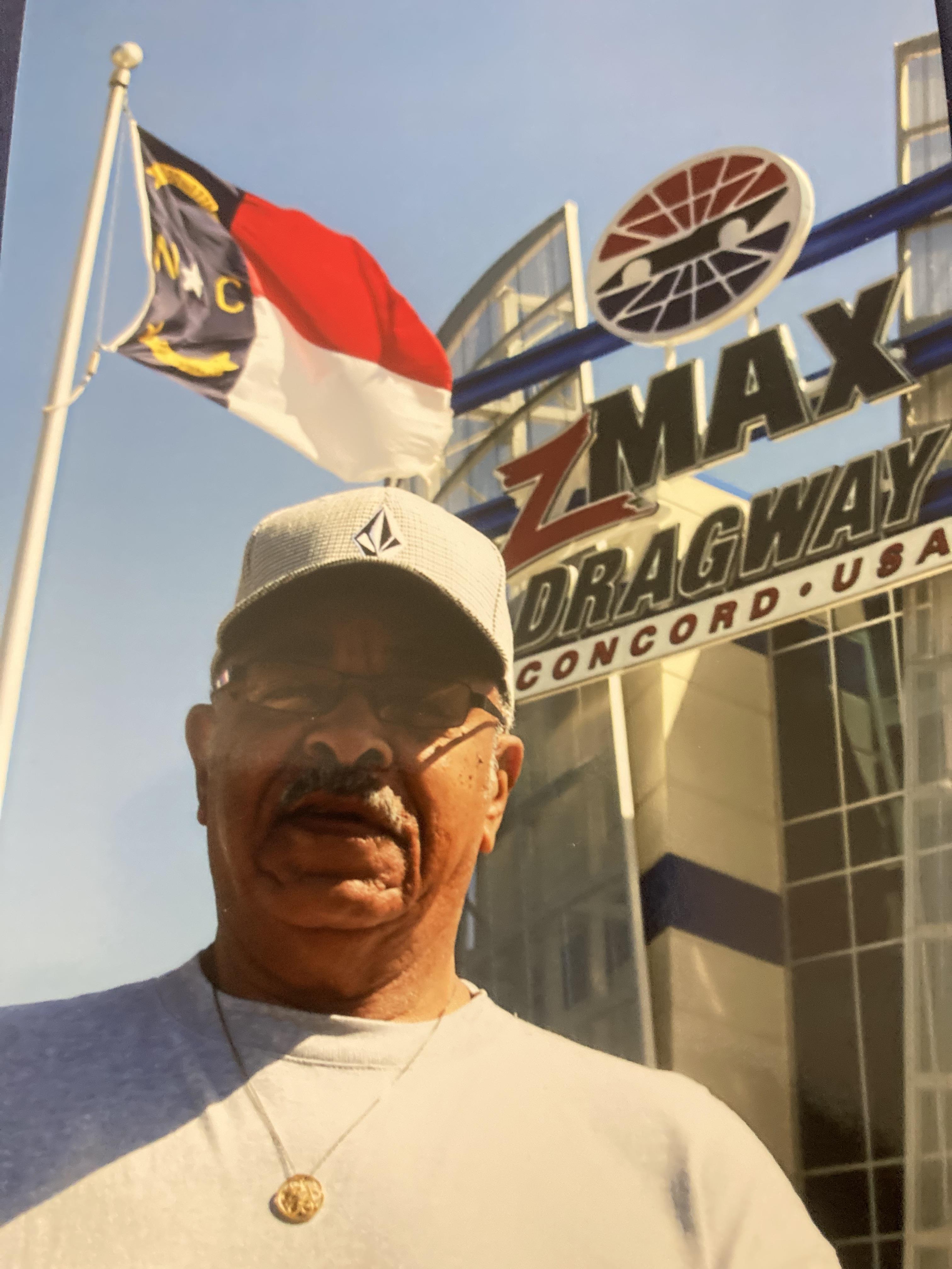 A man in front of a building with flags