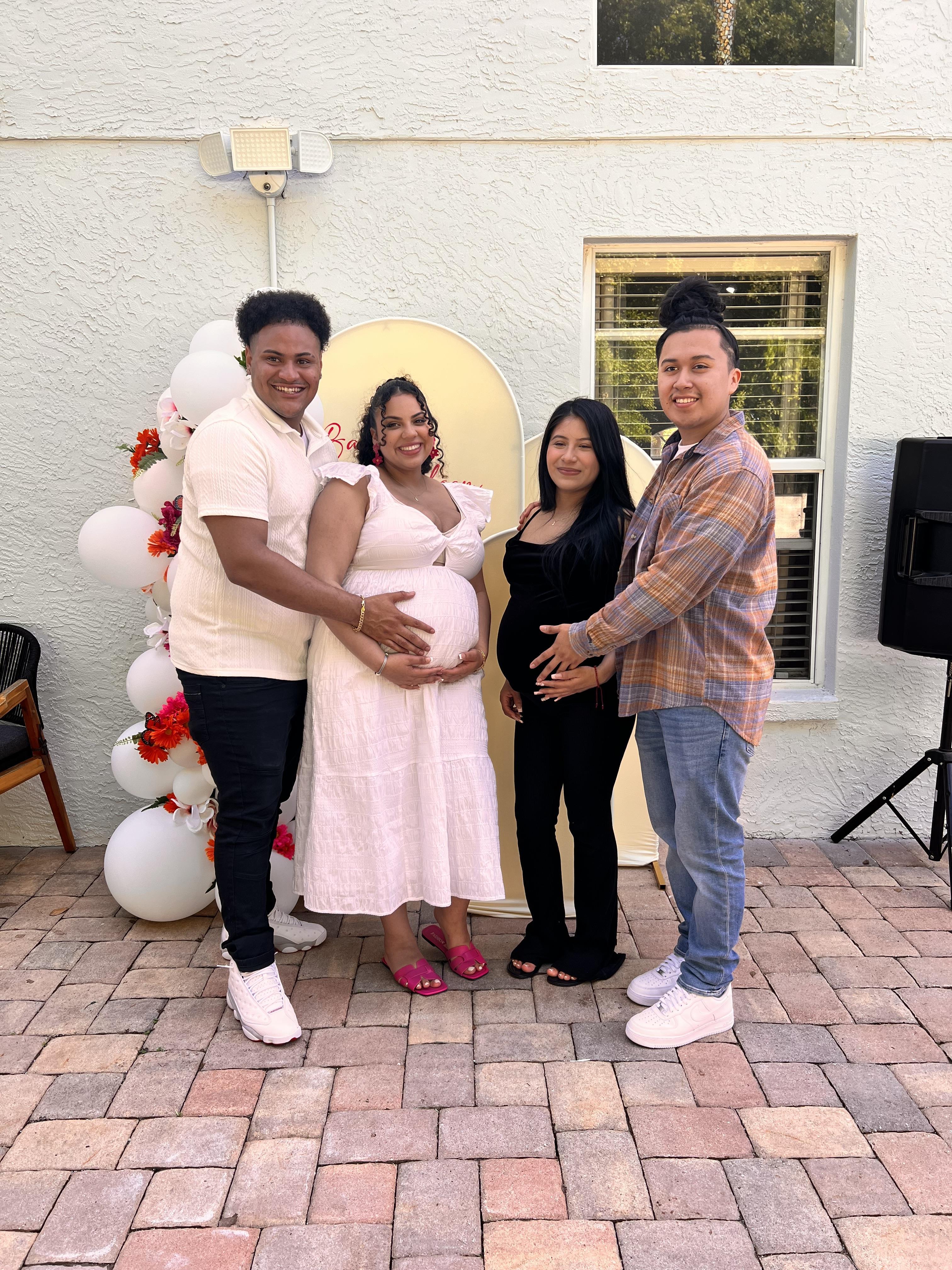 Four friends celebrate two upcoming births in a joyful backyard gathering.