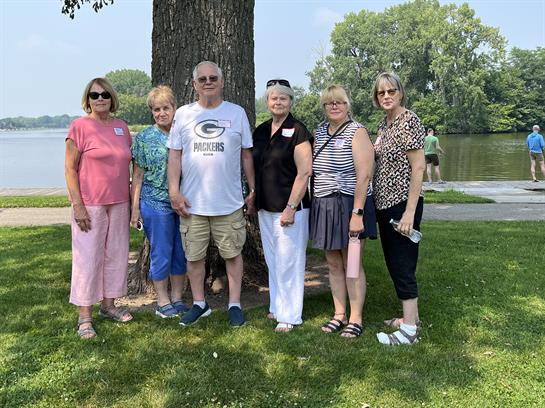 A group of people standing in front of a tree