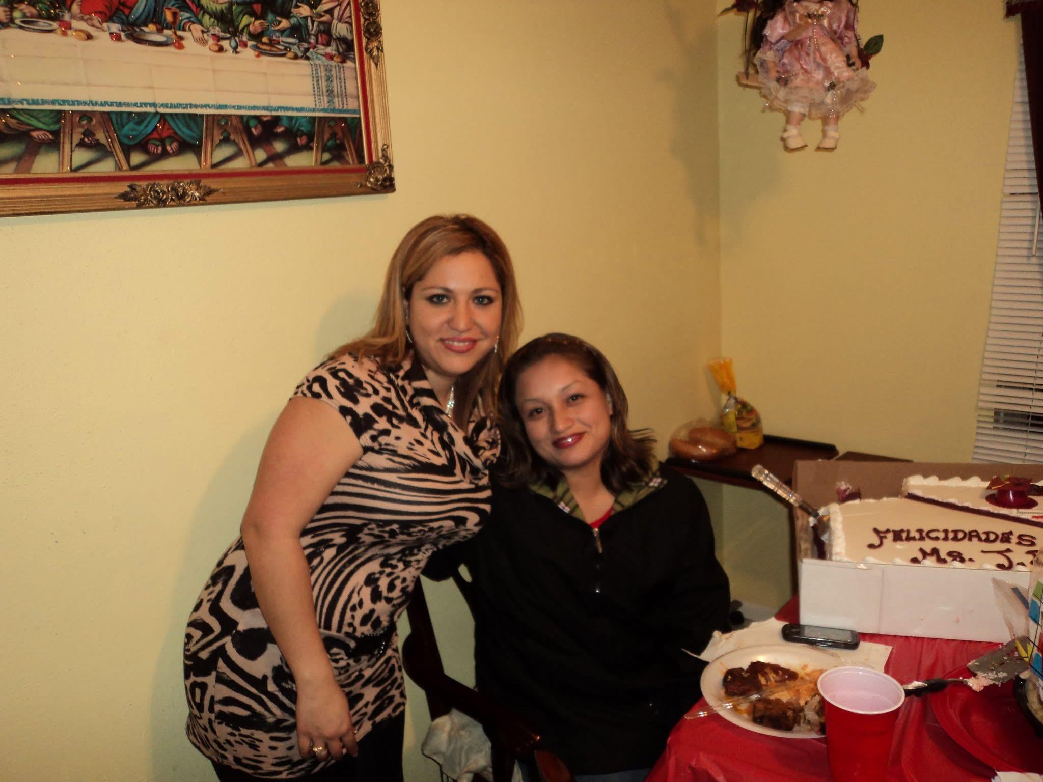 Two women enjoy a festive moment together while surrounded by food, decorations, and warm colors.