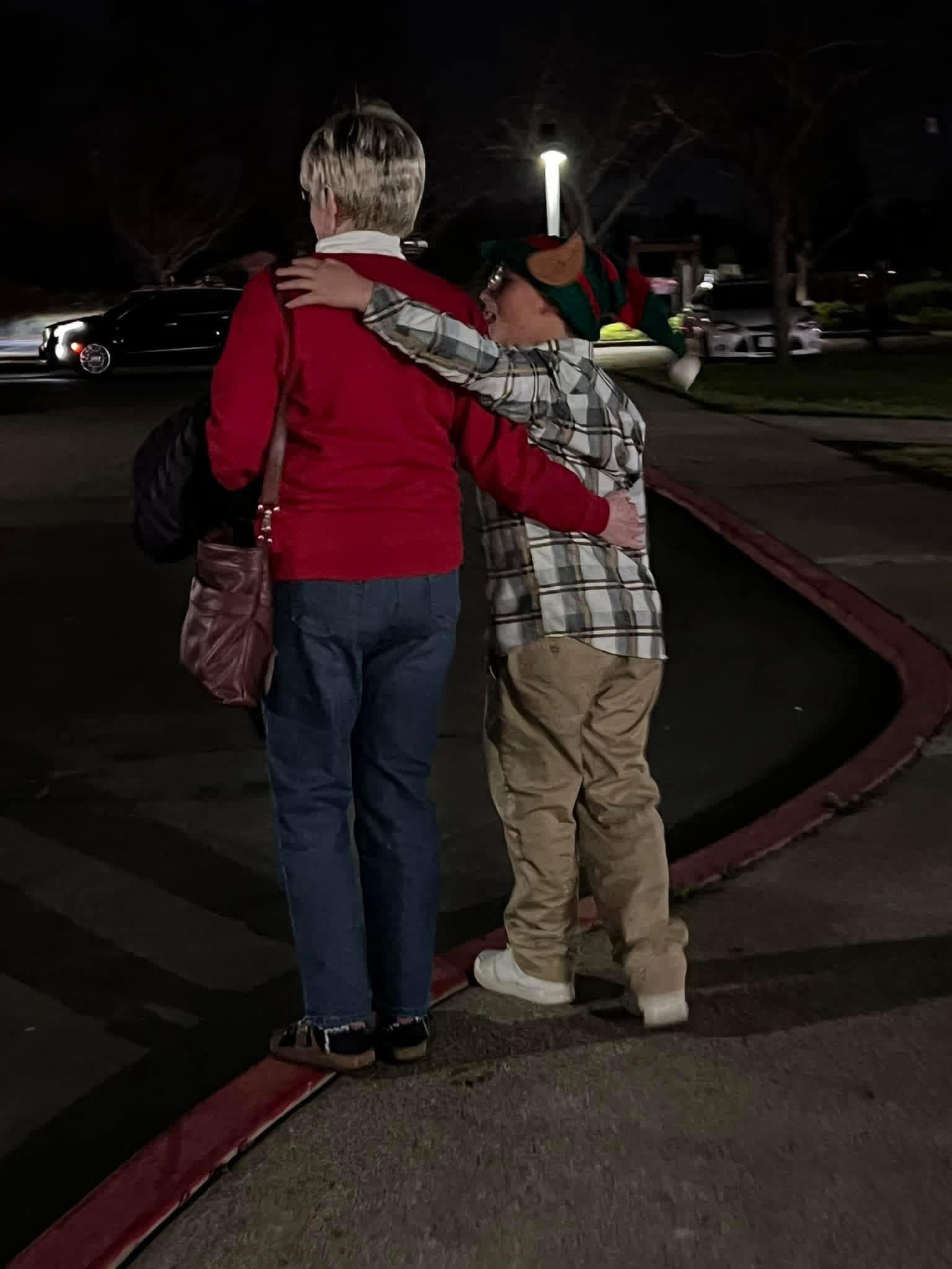 A woman and boy hugging at night