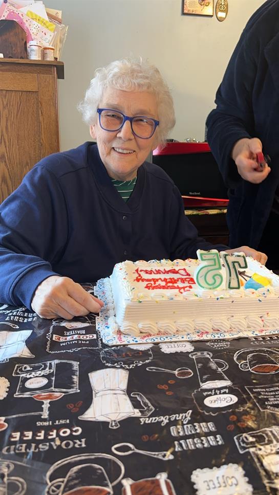 A woman sitting at a table with a cake