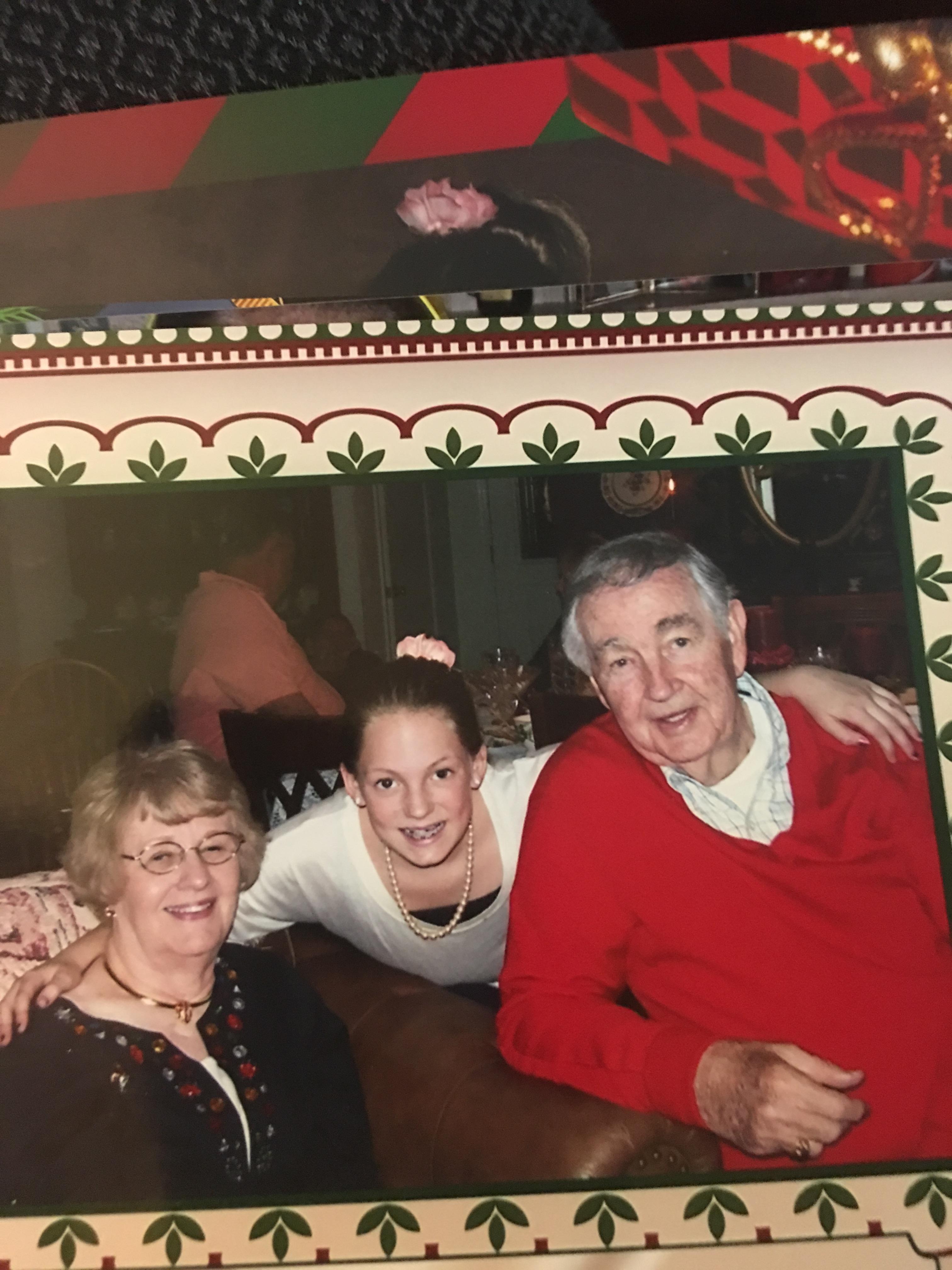 Three family members pose together joyfully during a festive gathering, showcasing warm smiles.