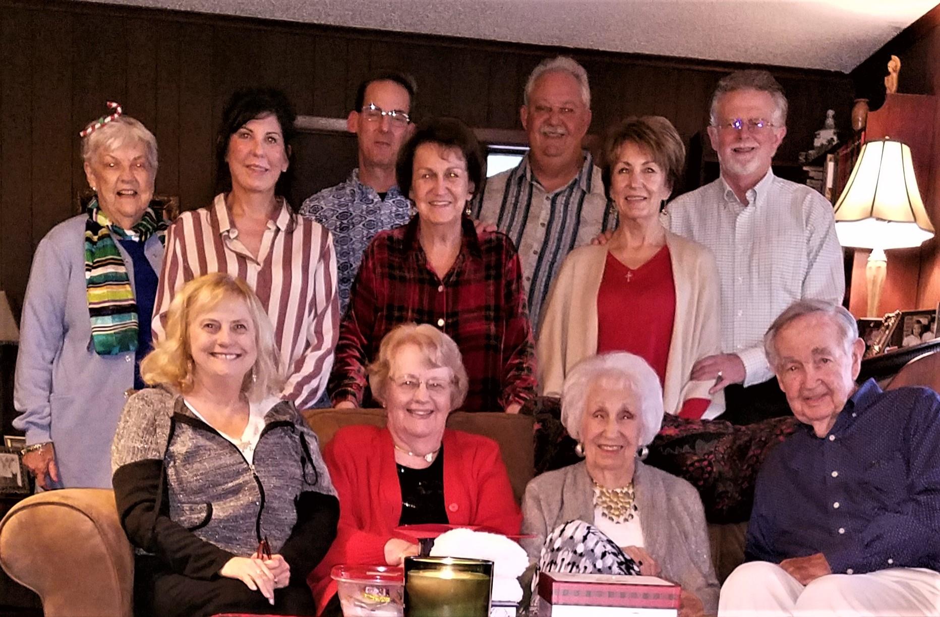 A cheerful gathering of friends and family celebrating together in a warm indoor setting.