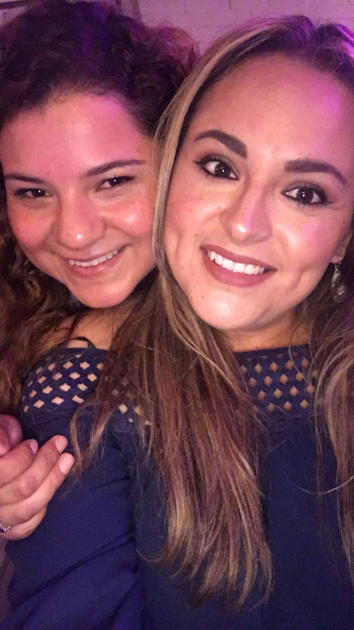 Two friends enjoy a fun moment, showing vibrant smiles in a lively setting filled with excitement.