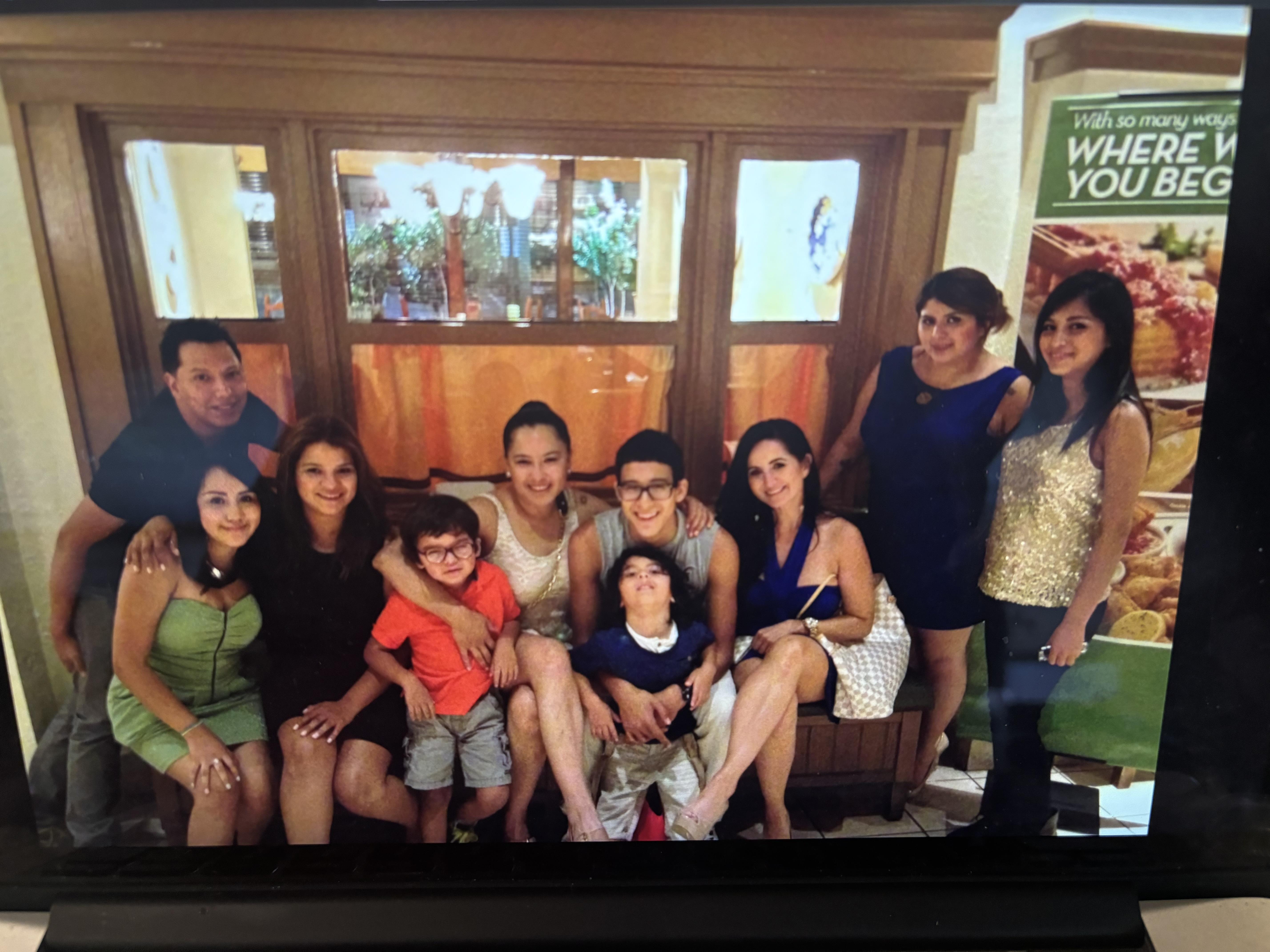 Group of family members smiling and posing together, sharing happy moments during a gathering.