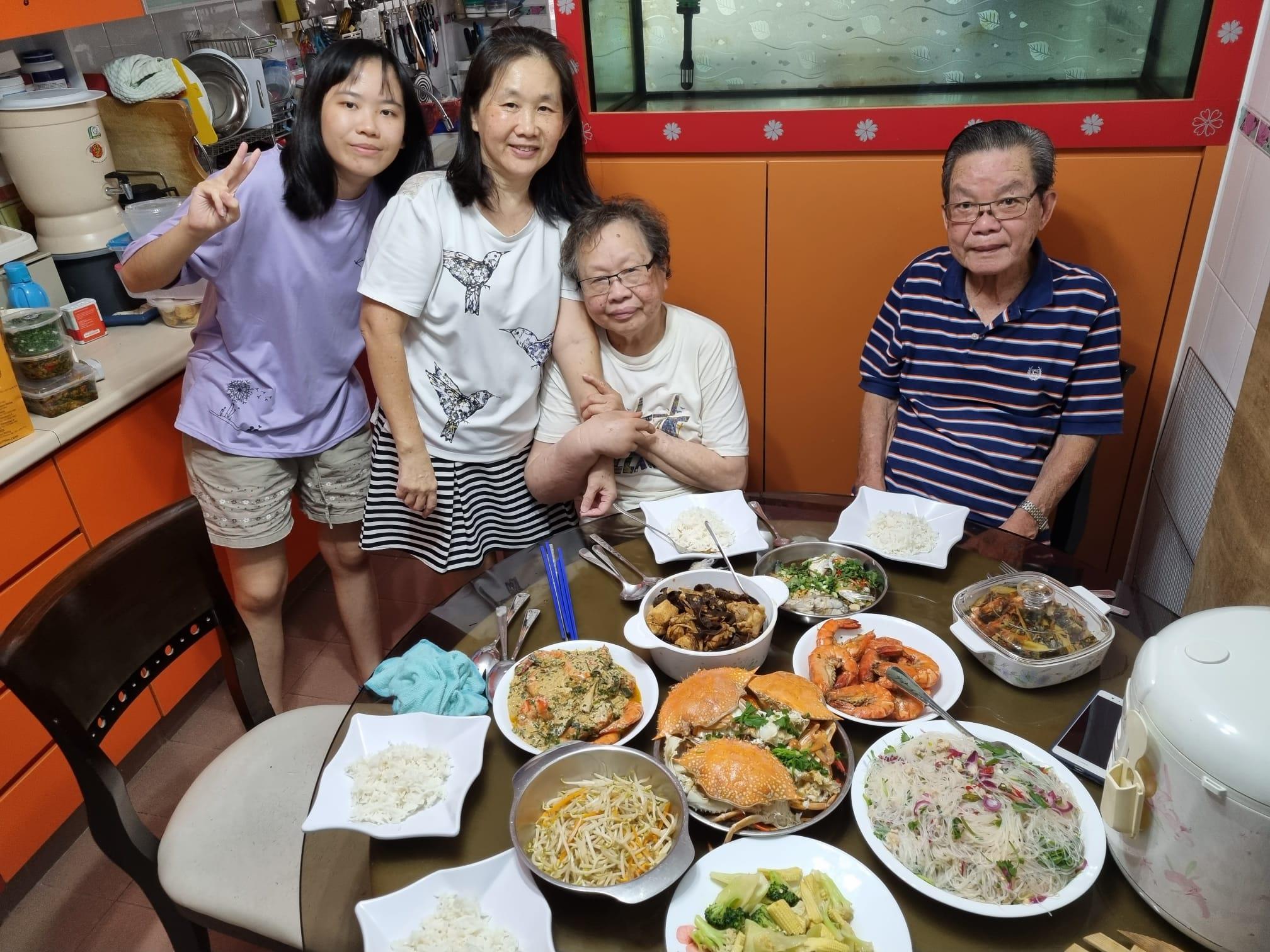 Four family members gather around a table filled with diverse dishes, sharing laughs and good food.