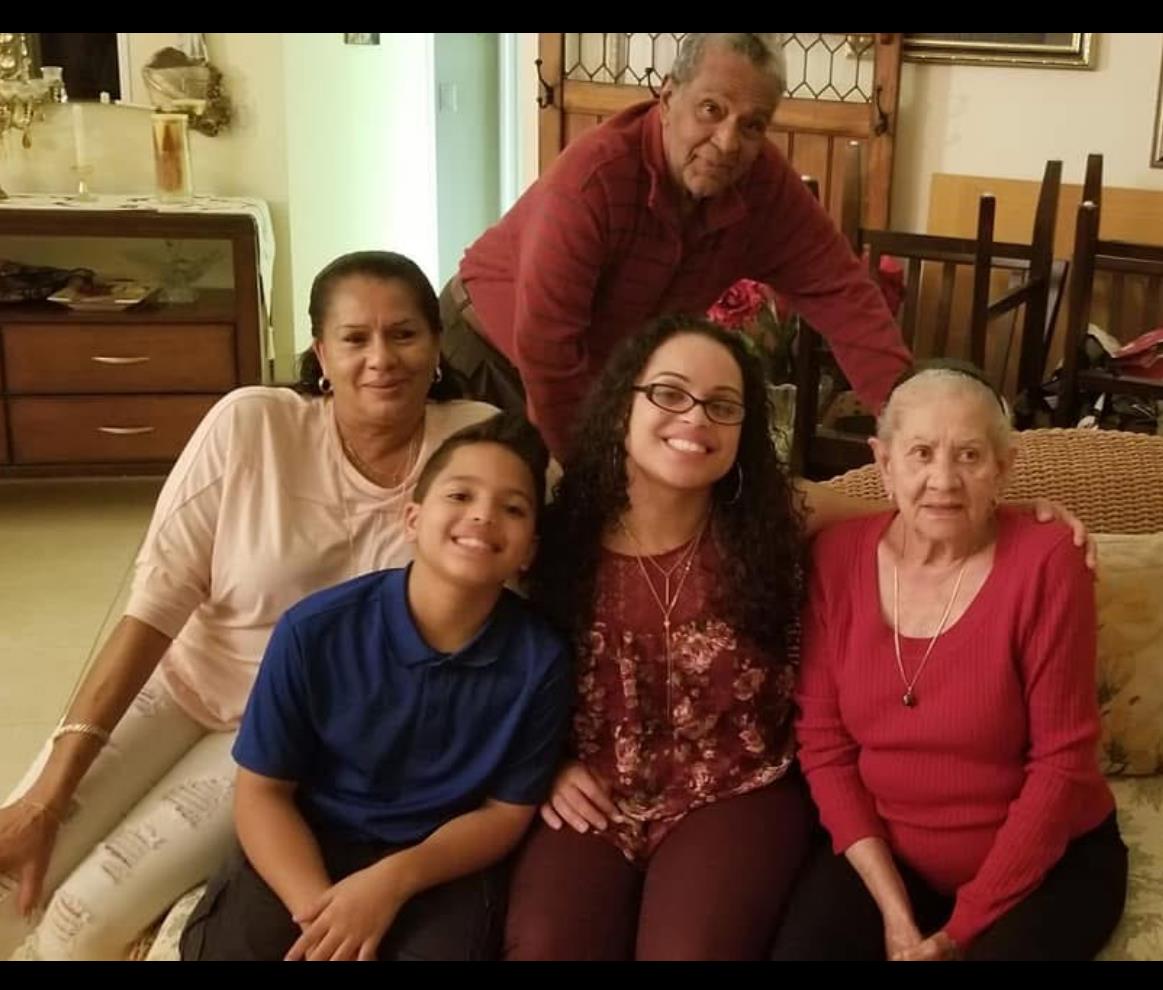 Family members gather happily in a warm living room, sharing smiles and memories.
