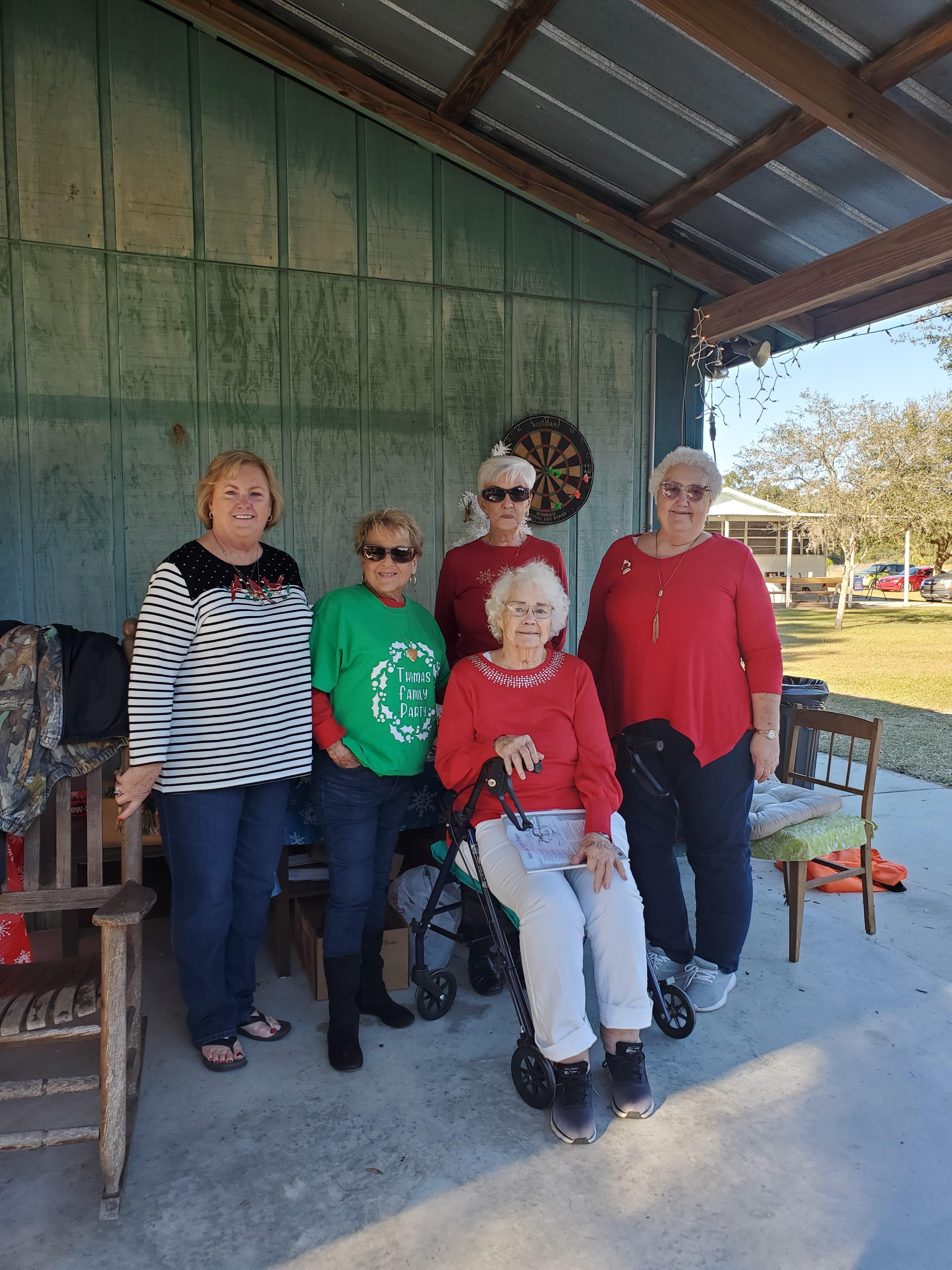 Group of friends dressed in colorful holiday clothes enjoy a sunny day together outdoors.