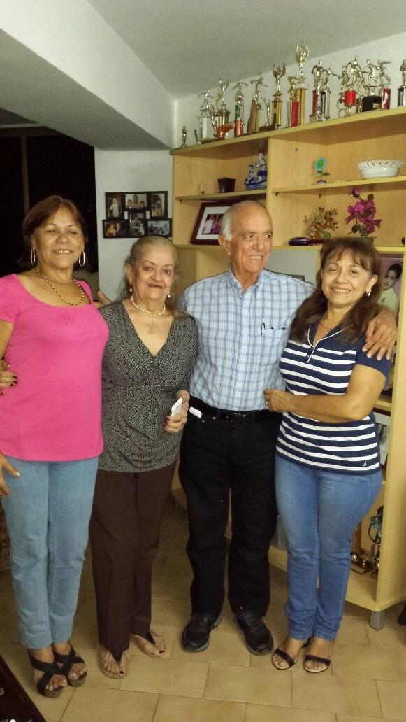 Four family members enjoy a joyful moment together in their living room, celebrating togetherness.
