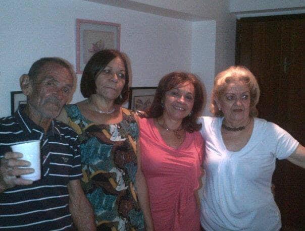 Four friends enjoy a lighthearted moment together in a cozy indoor space at night.