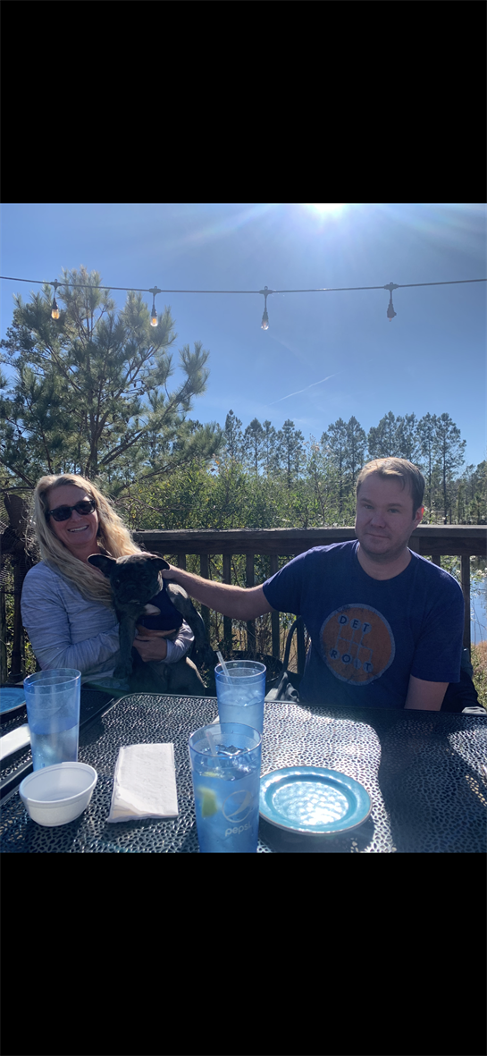 A man and woman sitting at a table with a dog