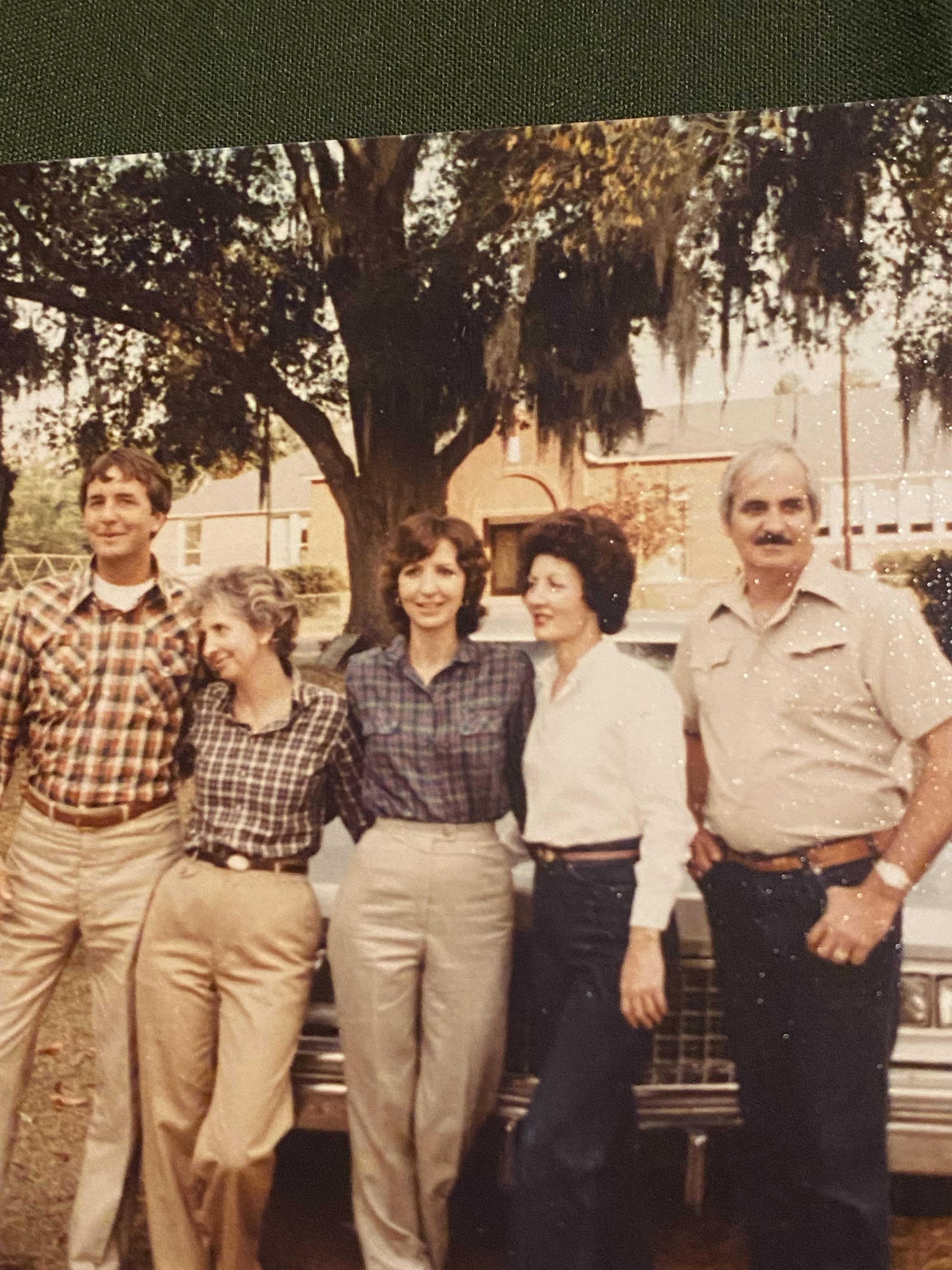 A group of people standing next to a car