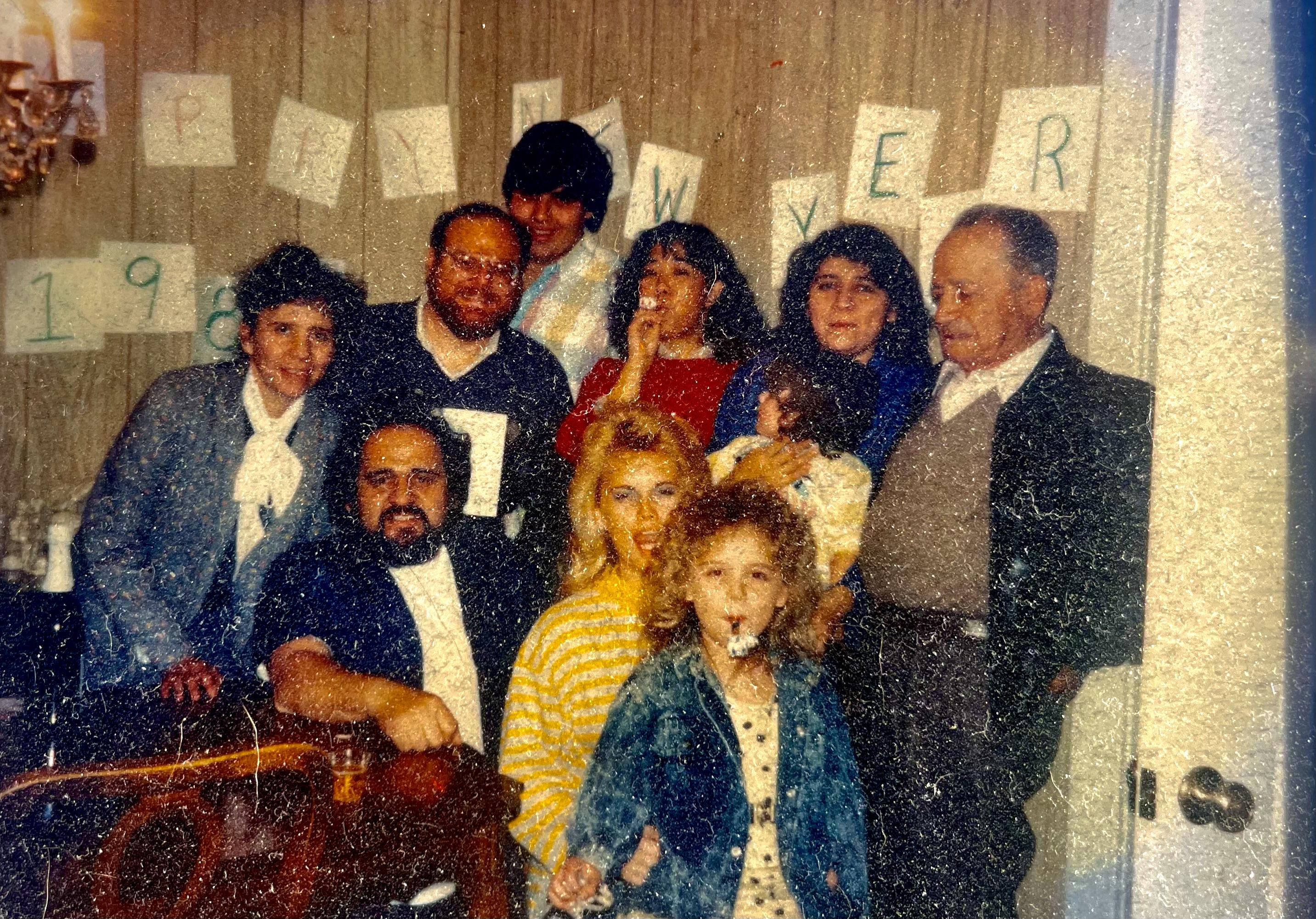 A lively family gathering features joyful interactions, with kids playing and adults smiling.