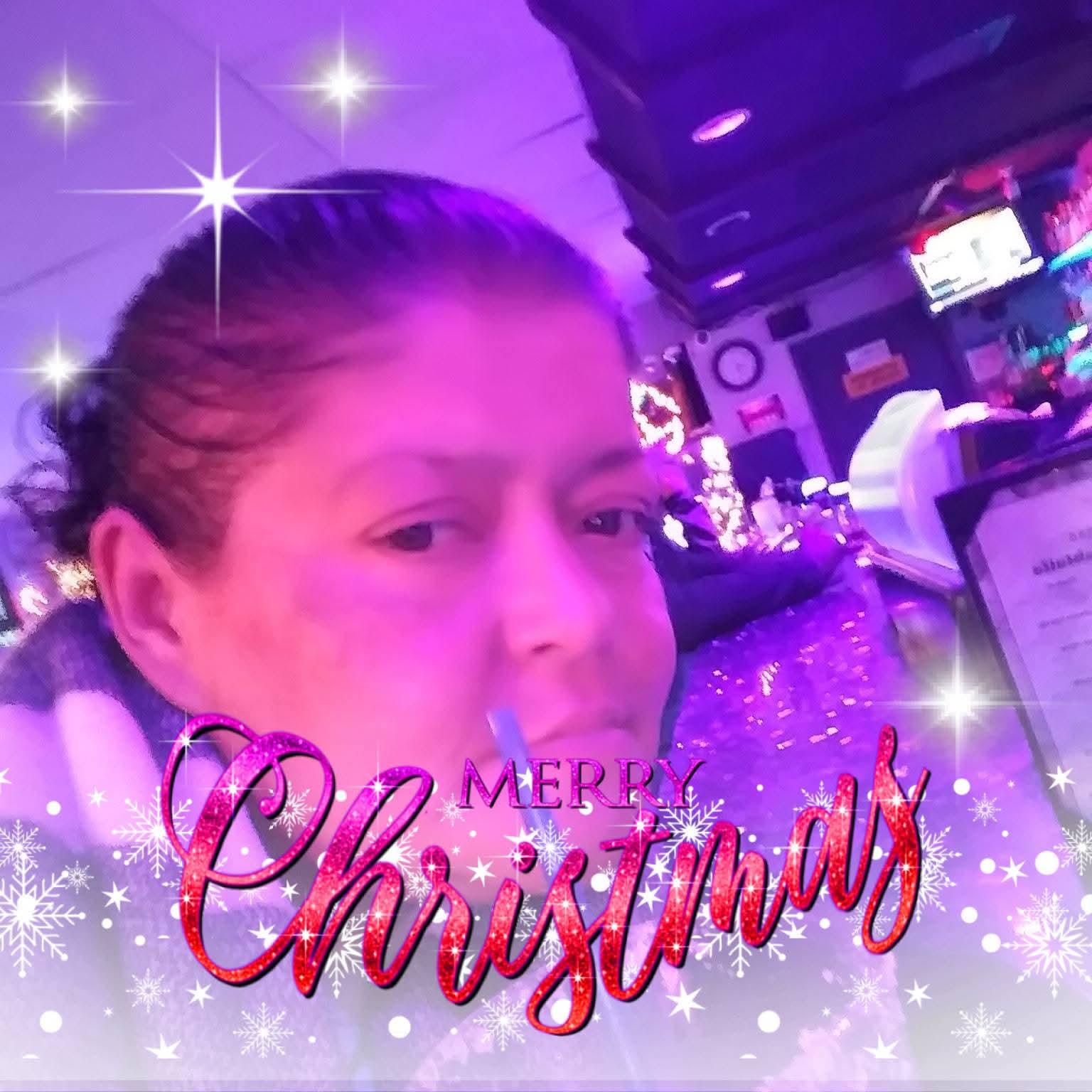 Woman enjoys Christmas festivities surrounded by colorful lights and cheerful atmosphere.