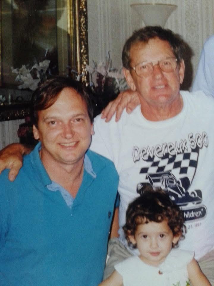 Three generations pose together in a living room, sharing smiles and creating memories.
