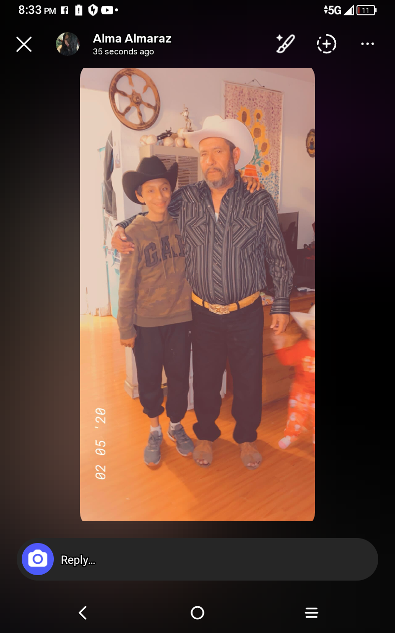 Two individuals pose for a picture in a residential setting with visible smiles and hats.