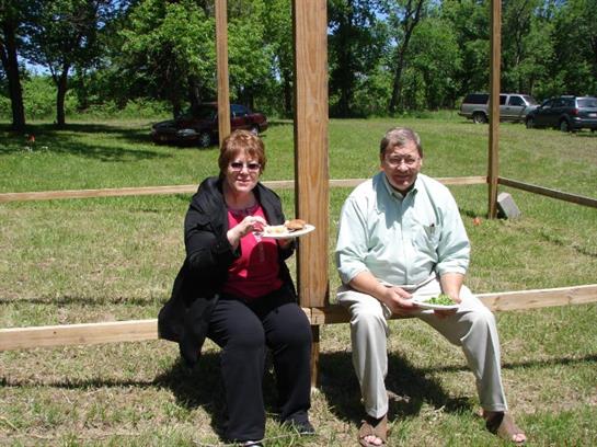 A couple sitting on a bench eating