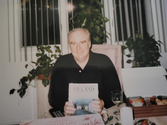 A man sitting at a table holding a newspaper