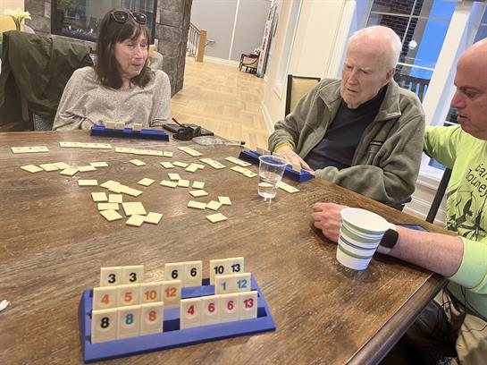 A group of people sitting at a table playing a game
