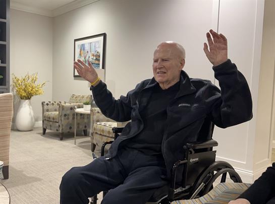 A man in a wheelchair with his hands up