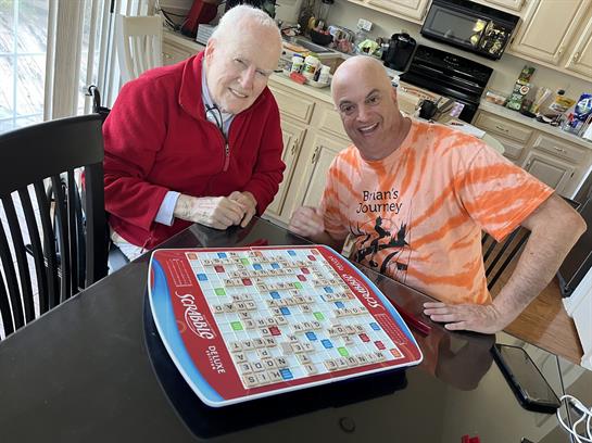 Two men sitting at a table with a board game