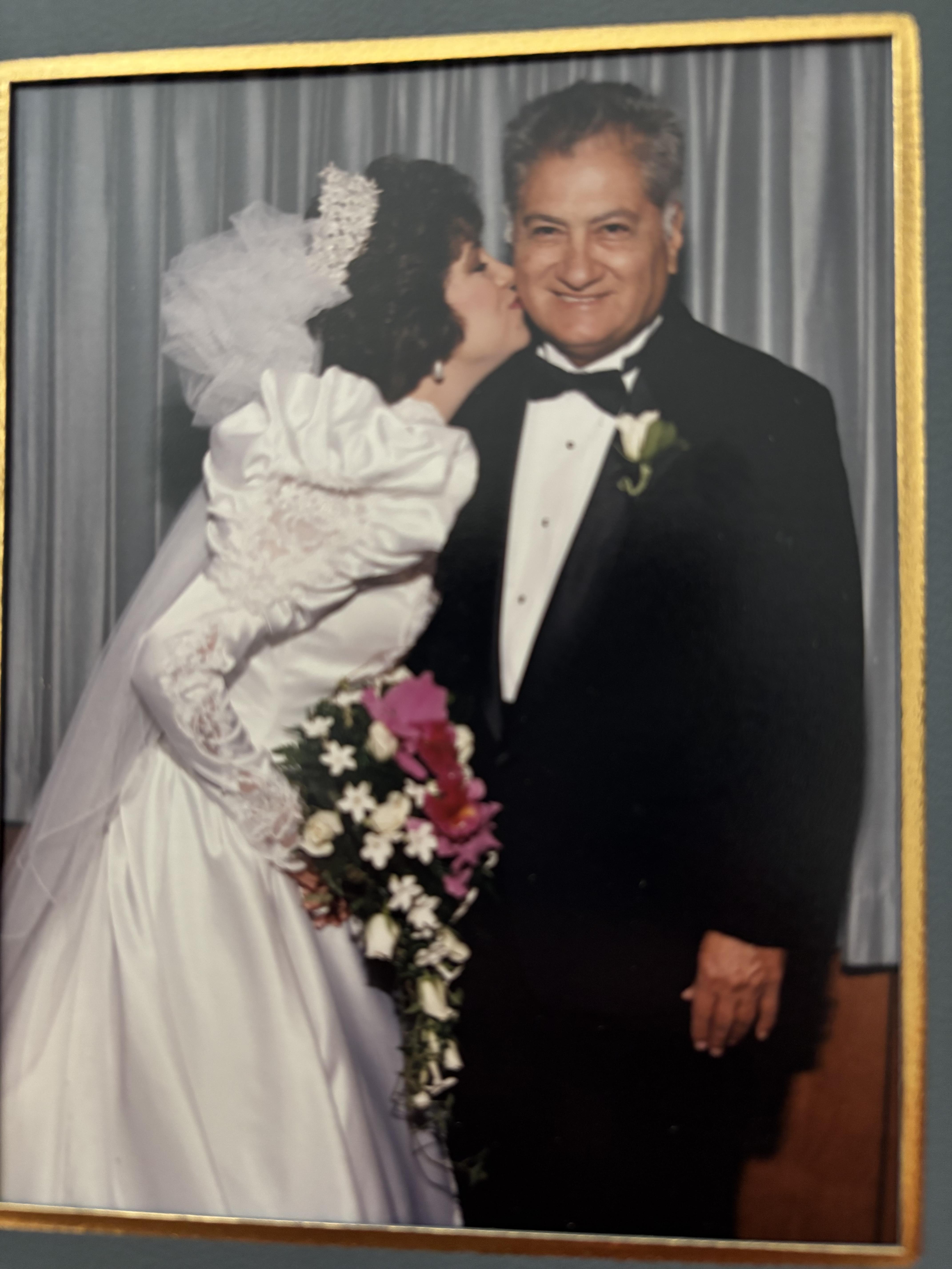 Bridal couple smiles together, celebrating their love during the wedding with floral arrangements.