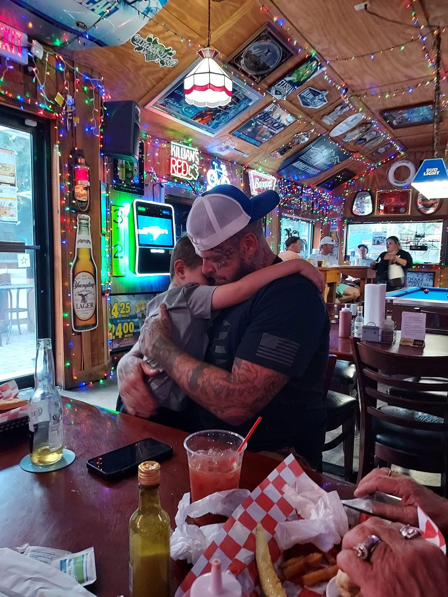 A man hugging a child at a restaurant