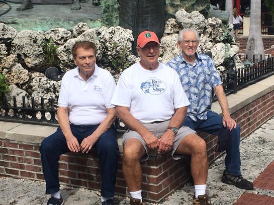 A group of men sitting on a brick wall